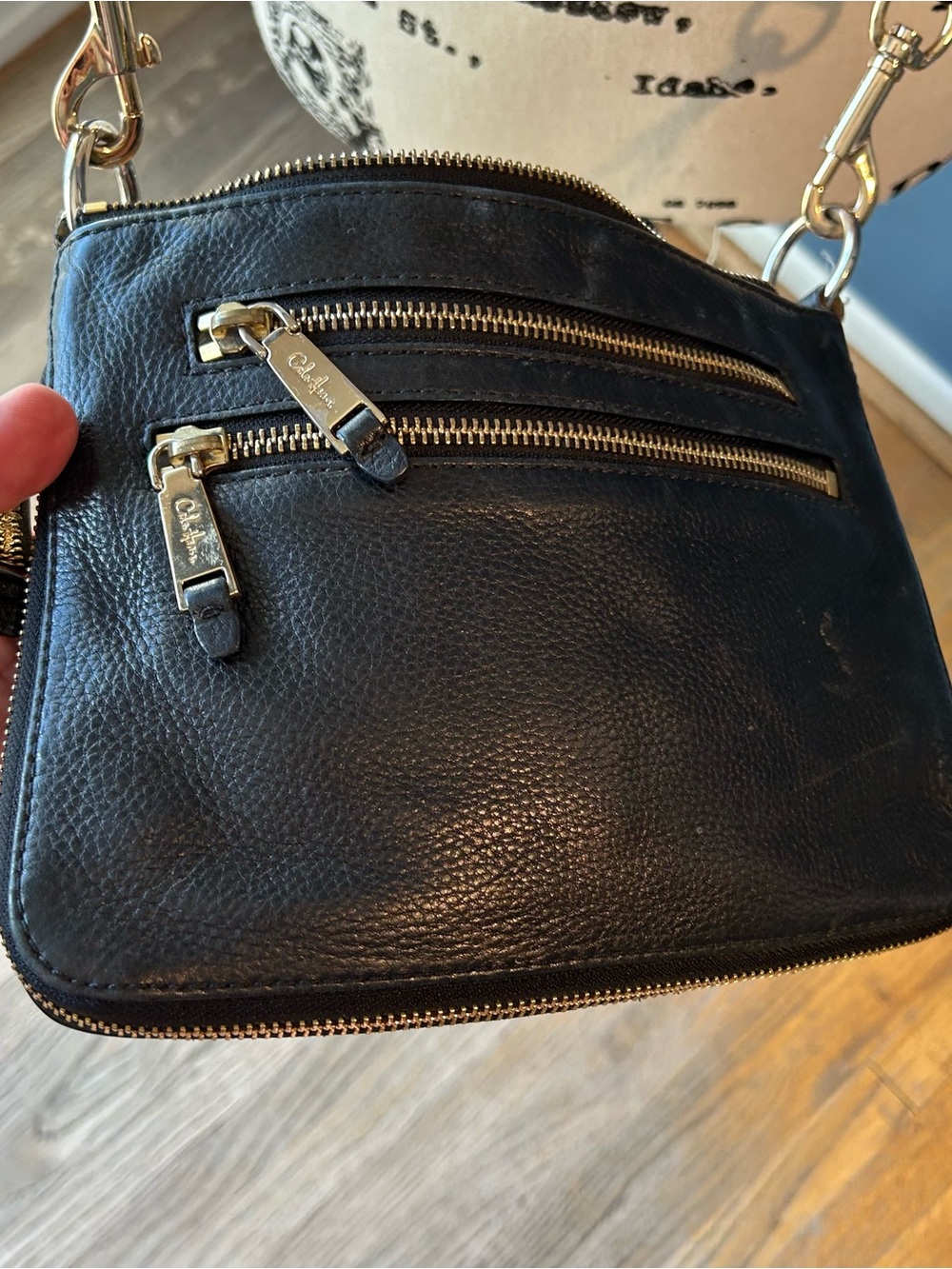 Cole Haan black leather expandable crossbody bag.